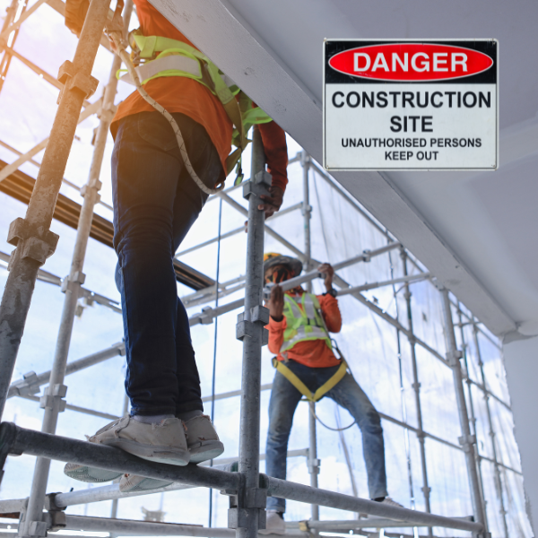 Dos trabajadores de la construcción con equipos de seguridad contra caídas cerca de una señal de advertencia que dice "Sólo personal autorizado". según Accidentes en la construcción según Univision.