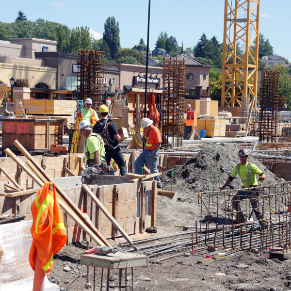 Una obra en construcción a pleno rendimiento con múltiples trabajadores dedicados activamente a sus tareas diarias.