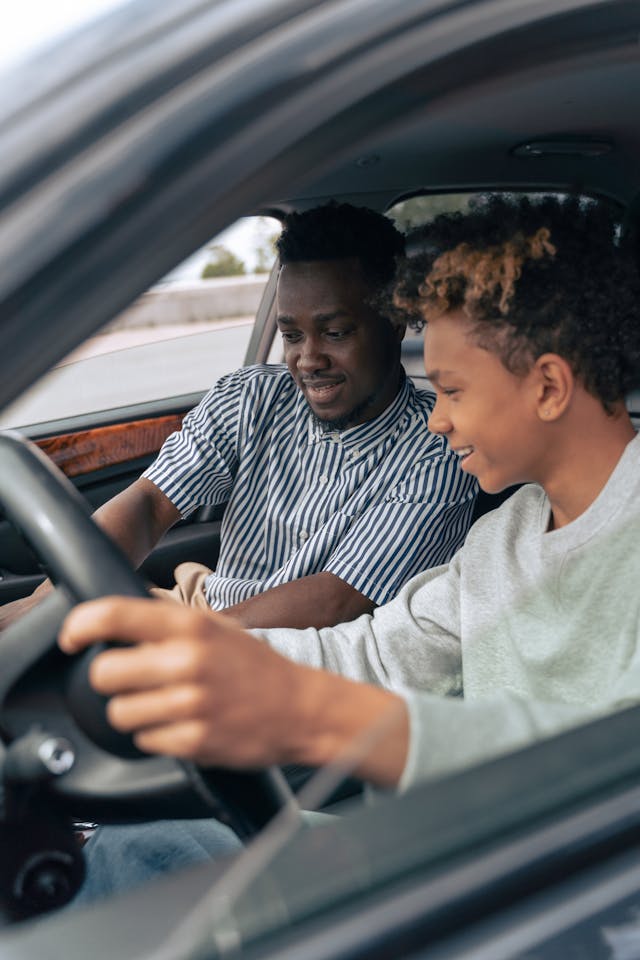 a parent teaching teen driver accidents courses to son in car