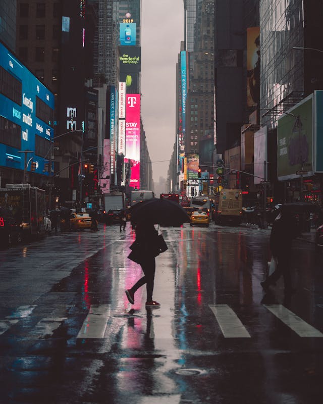 person with umbrella walking in NYC on a cloudy day during NYC pedestrian crosswalk accidents awareness