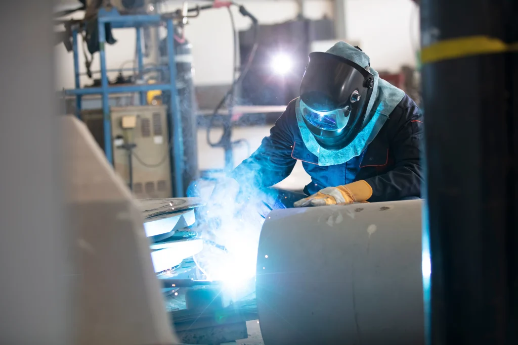 Specialist welder wearing PPE doing arc welding with sparks on a construction structure