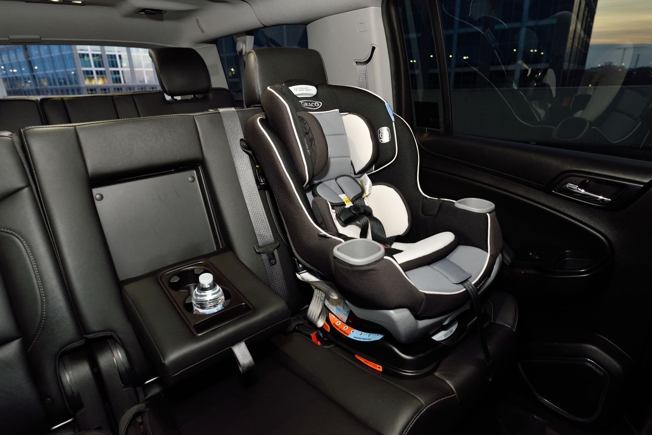 Imagen de la Semana de la Seguridad de los Niños Pasajeros en la que se ve una silla infantil de coche fijada en la parte trasera de un turismo aparcado.